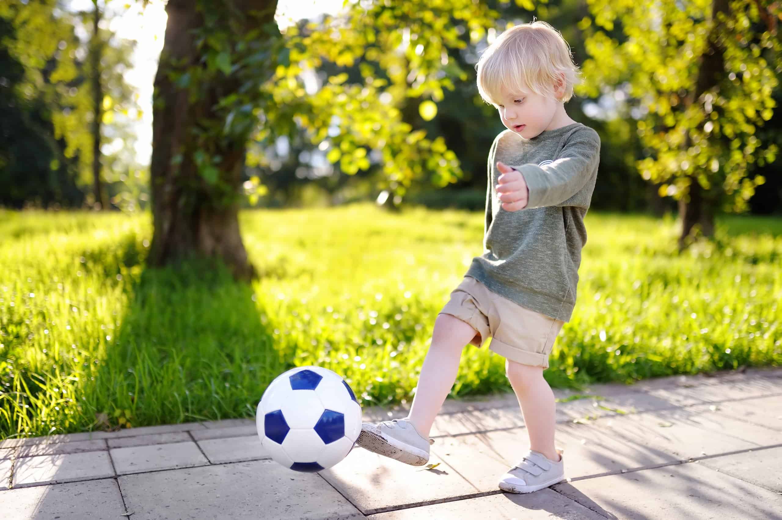toddler kicking a ball