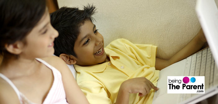 Siblings playing on a laptop