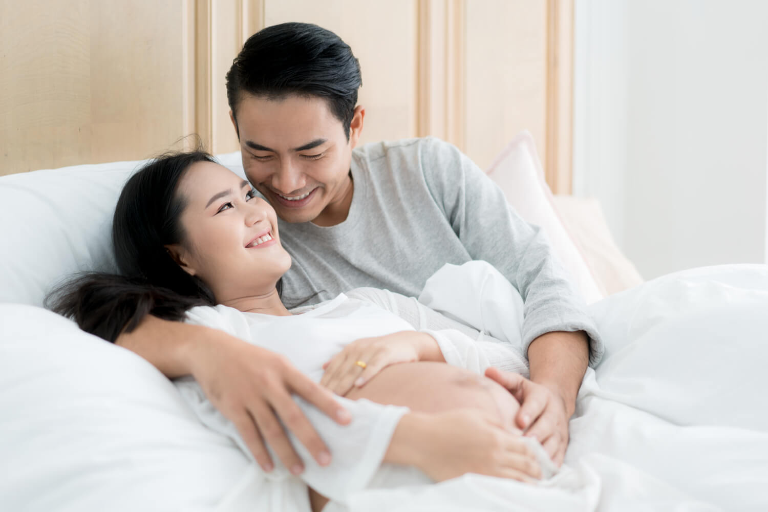 pregnant couple in bed