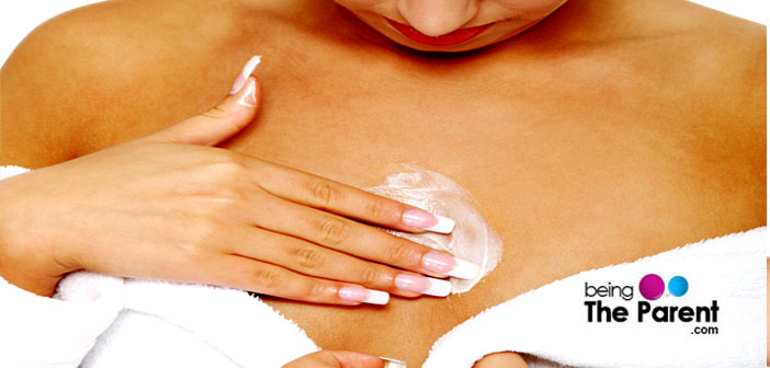 Woman using lotion on breasts