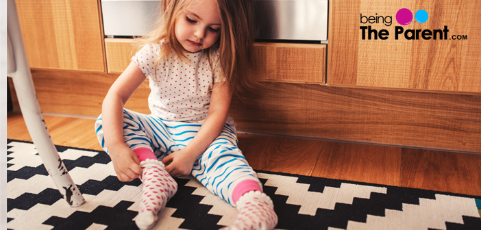 Little girl puts on socks