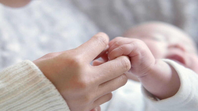 baby holding mom hand