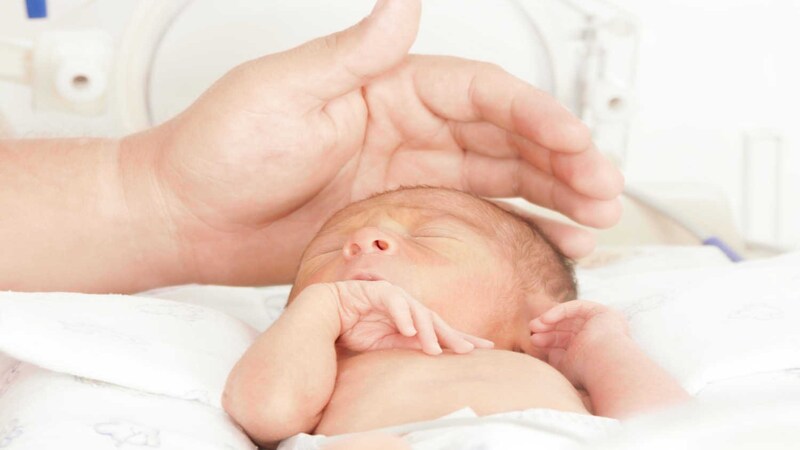 mom touching new born baby
