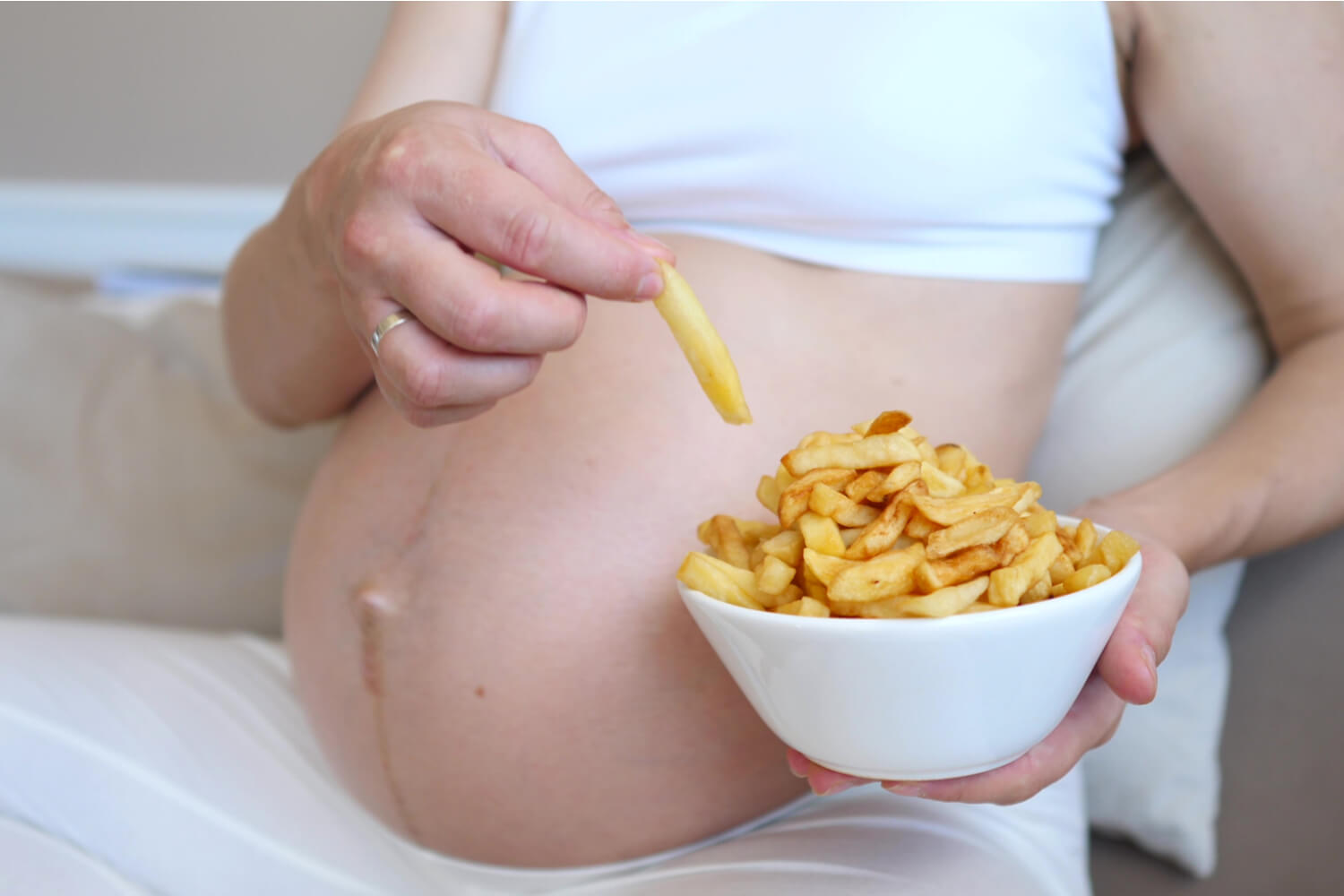 Pregnant woman eating frech fries