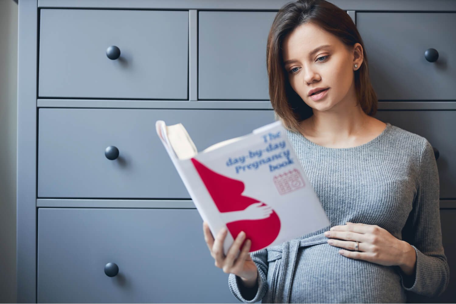 regnant woman reading pregnancy book