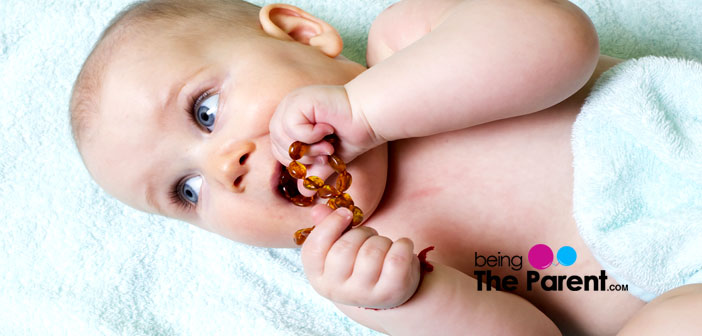 baby chewing on amber necklace