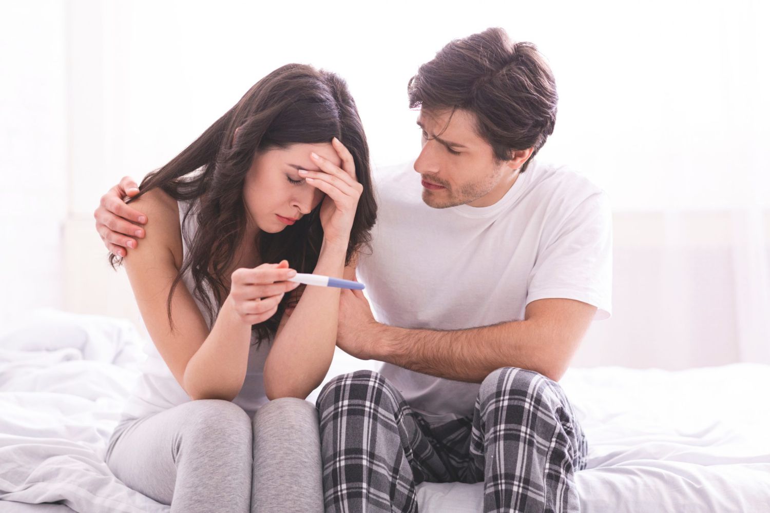 couple sad with pregnancy test