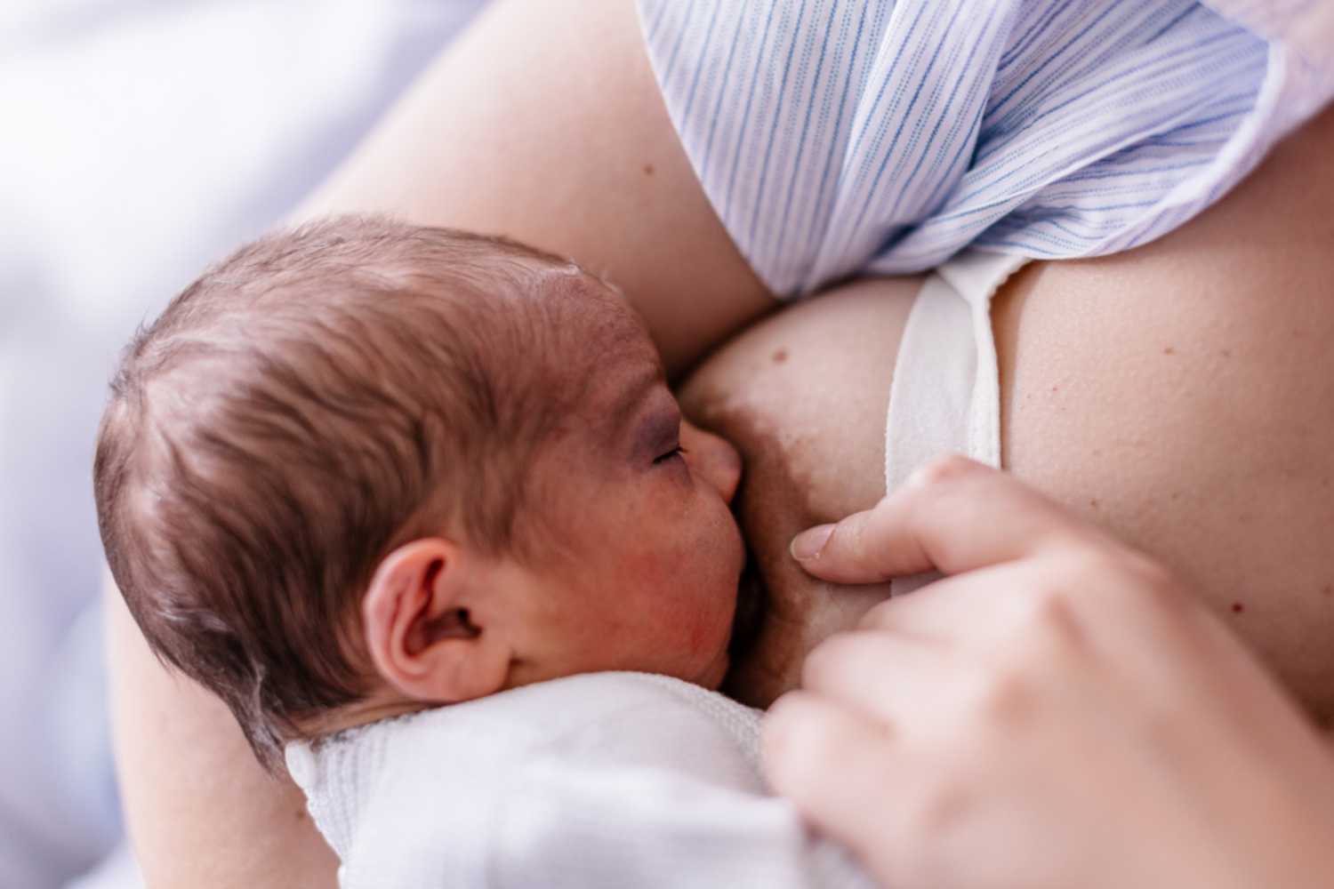mother breastfeeeding newborn