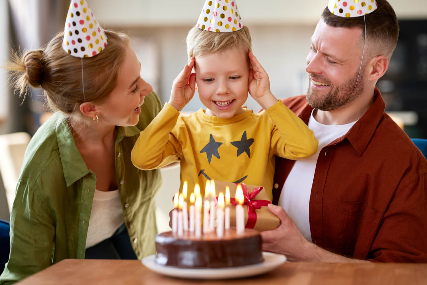 birthday boy with his parents and cake