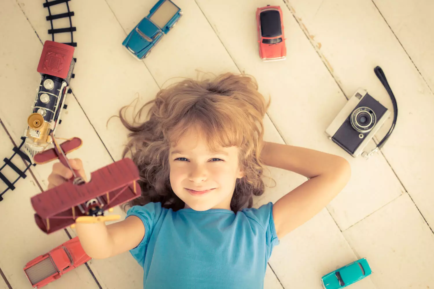 girl playing with vintage car , trains , plane