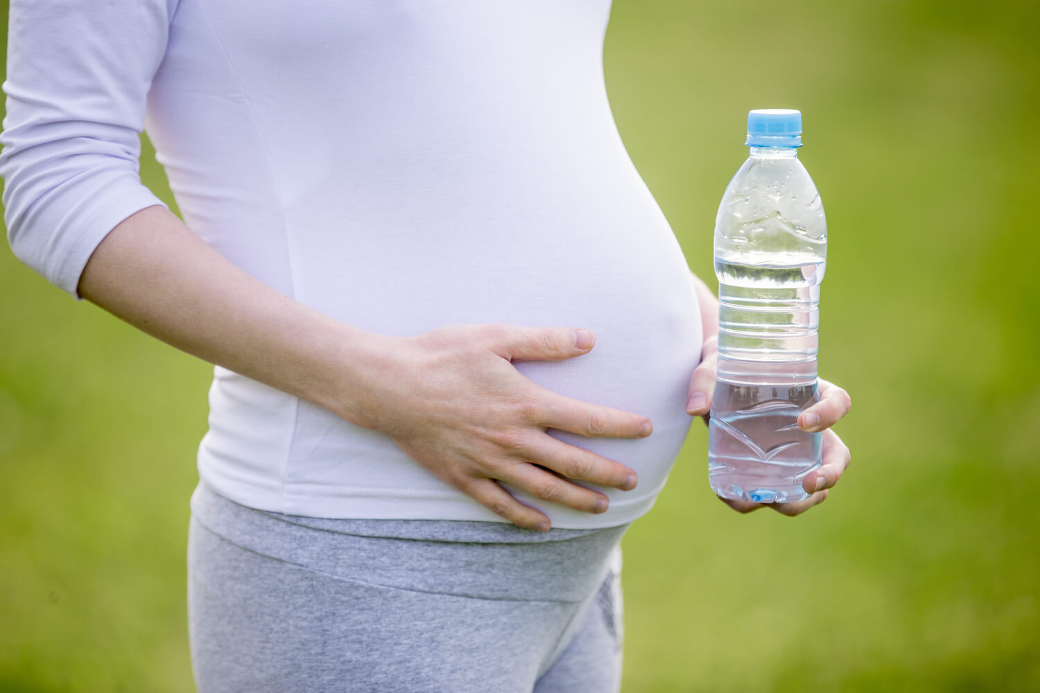 pregnant woman holding bottle water