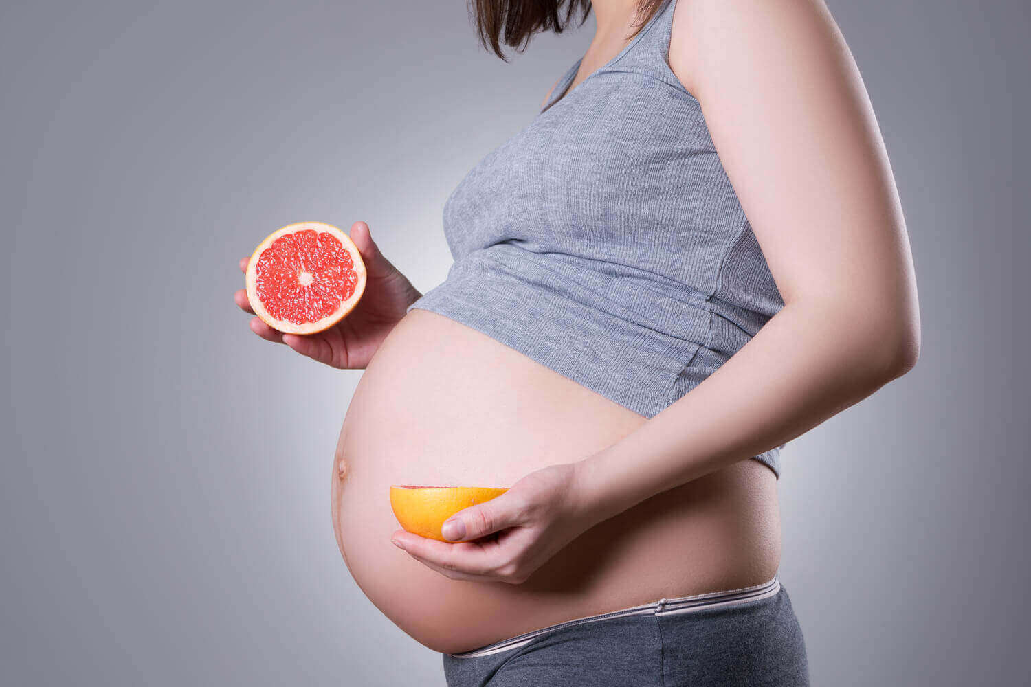 pregnant women holding grapefruit