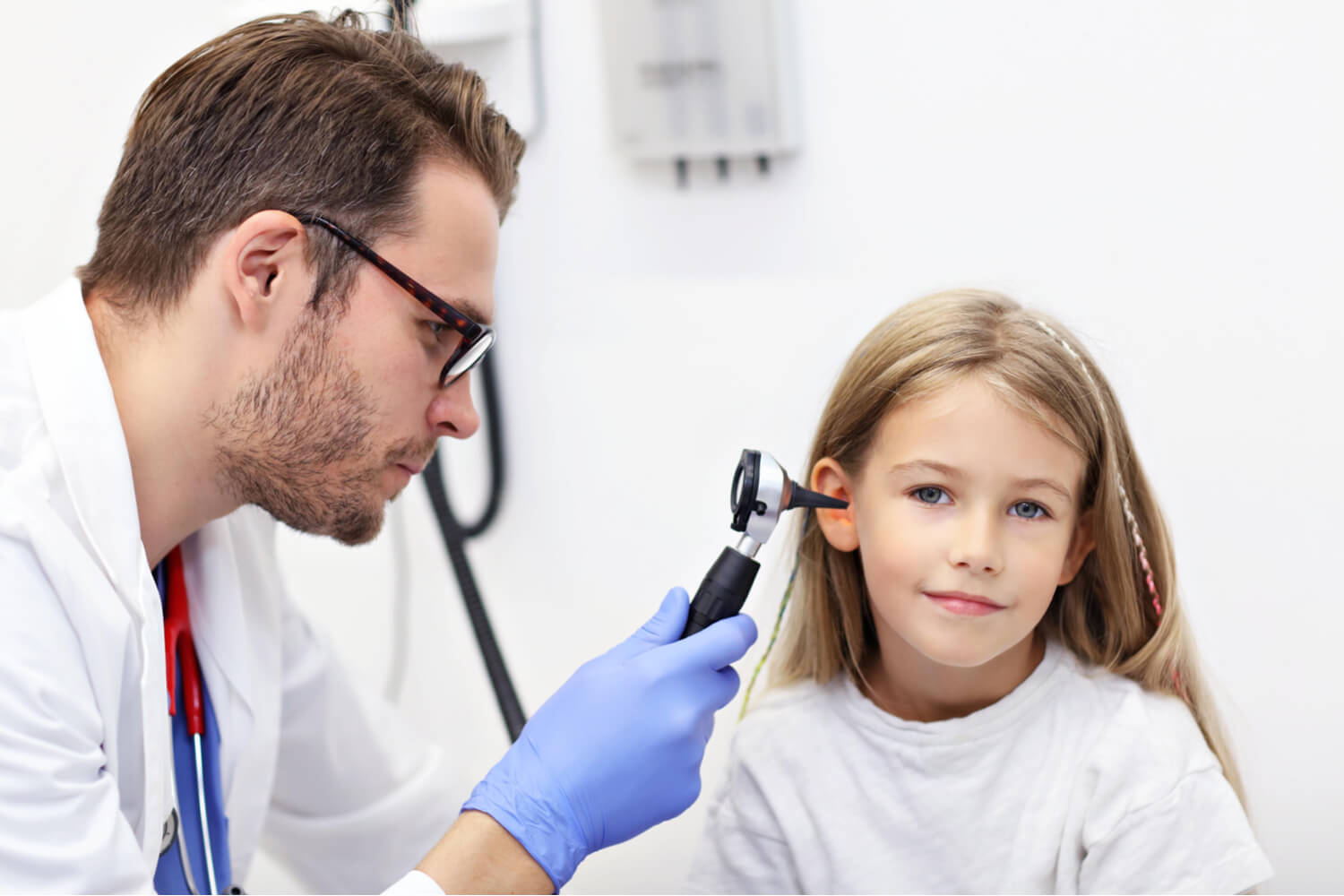 doctor checking girl's ear