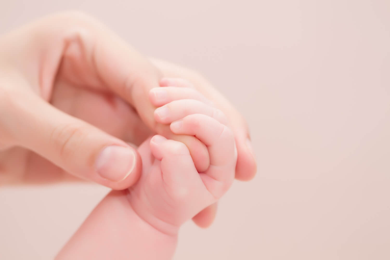 baby grasping mom hand