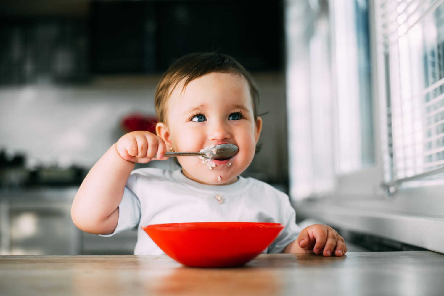 baby eating puree with spoon