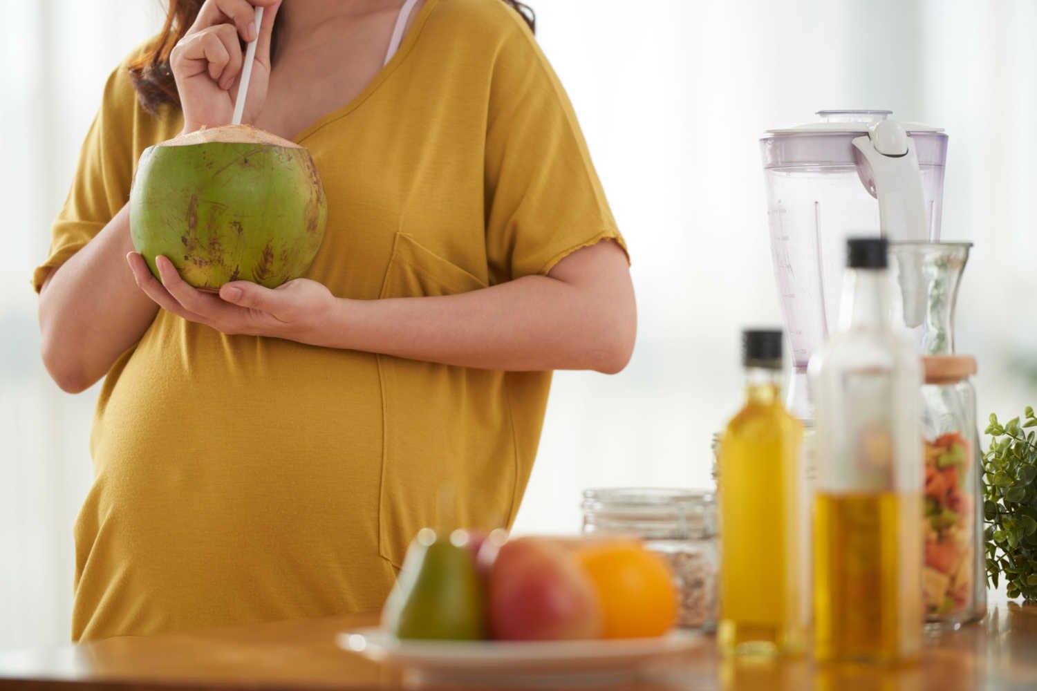 pregnant women sipping coconut water