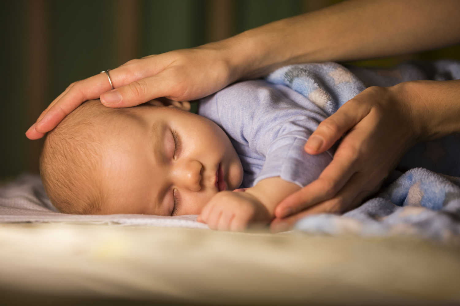 mom changing baby sleeping position