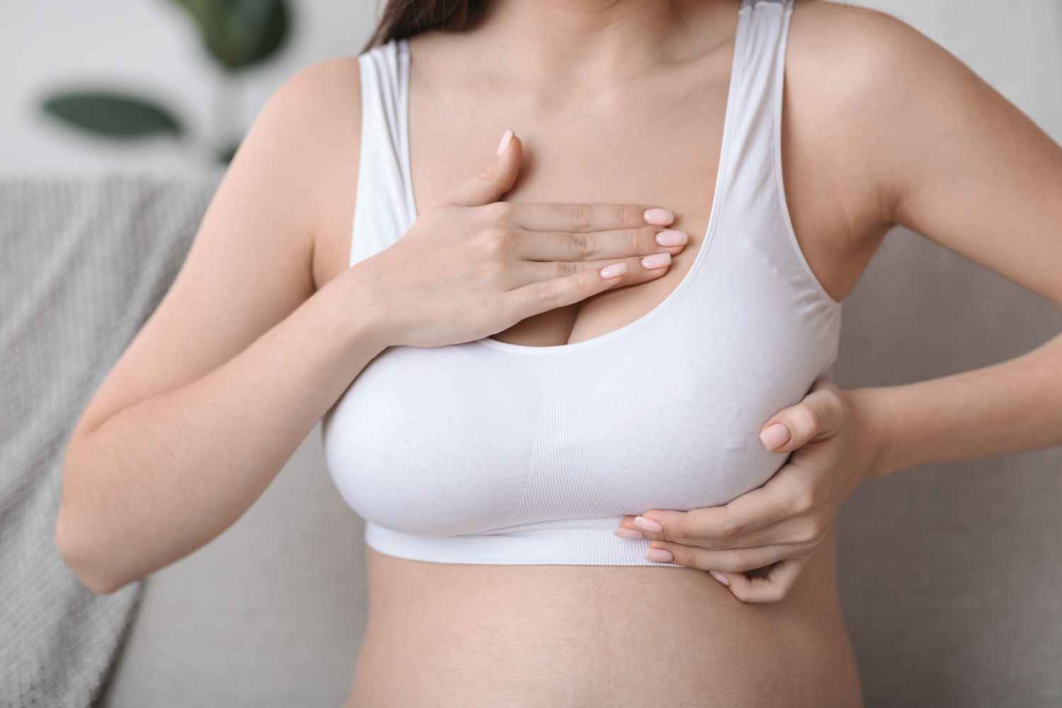 Pregnant woman checking her breasts