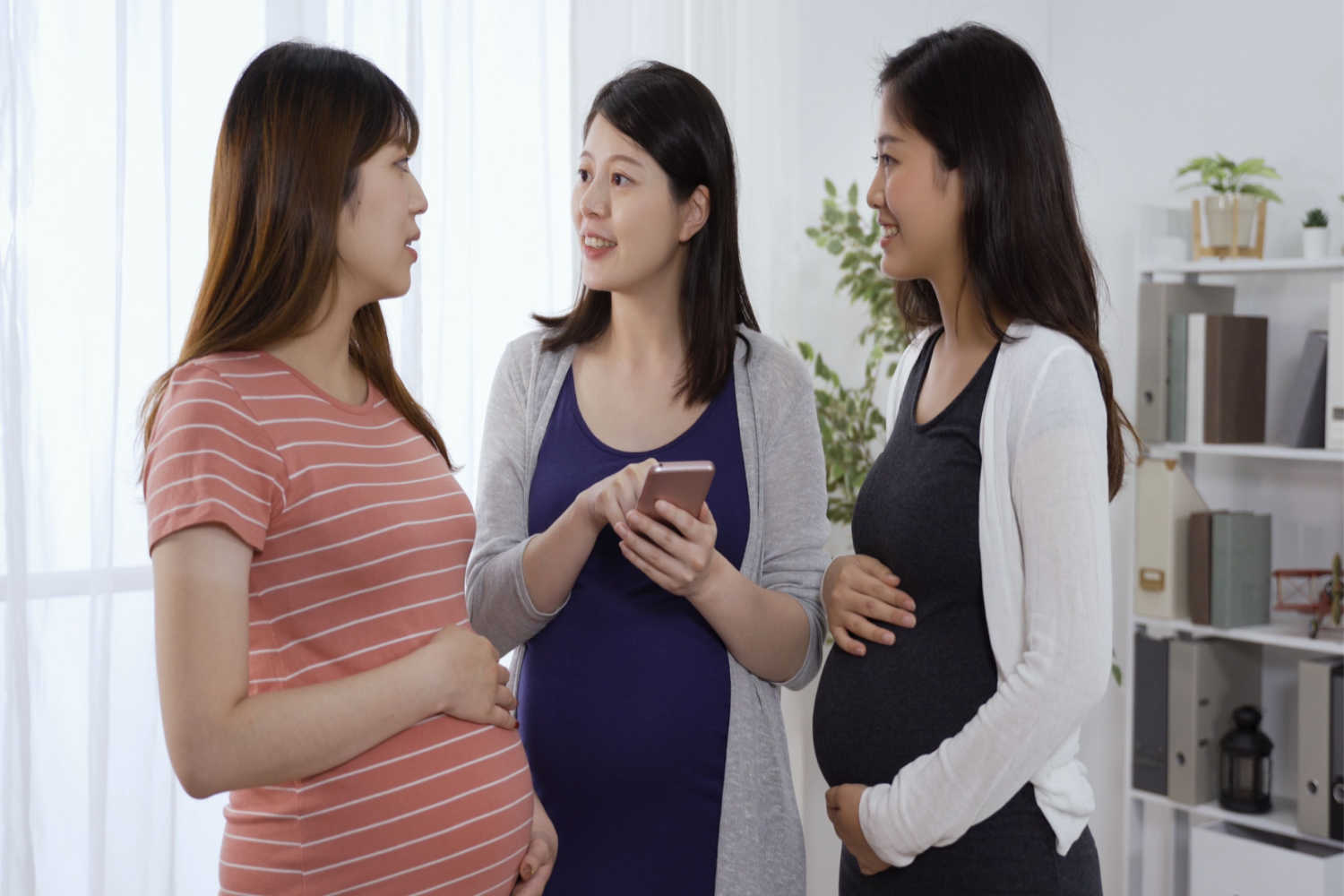 three pregnant women discussing 