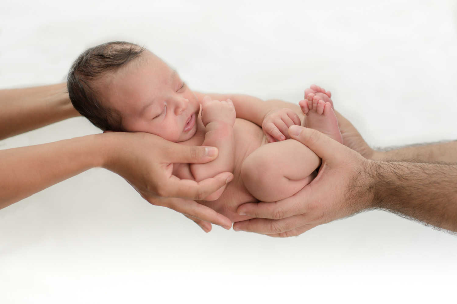 newborn held in parent's hands