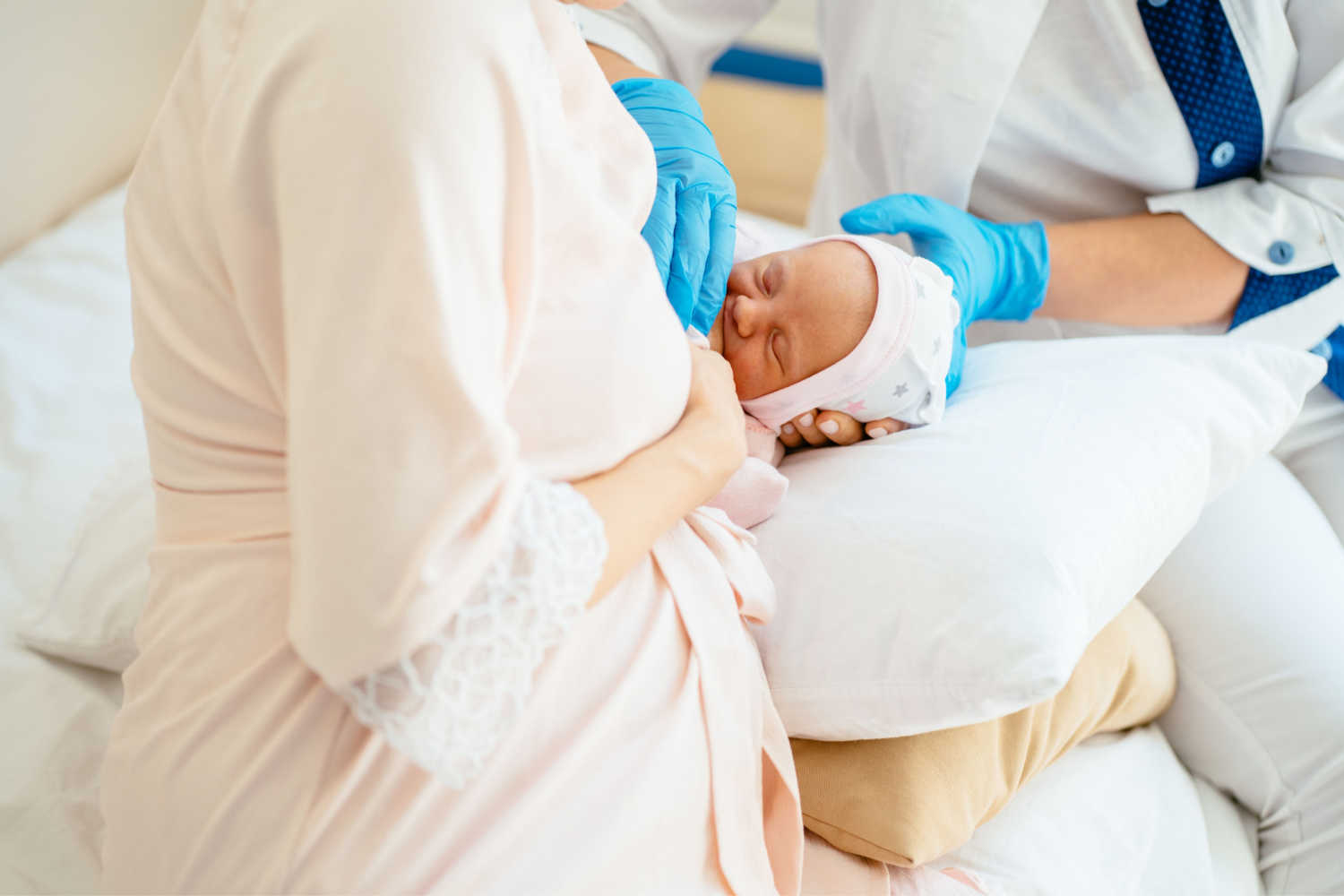newborn breastfeeding with the help of a lactation consultant