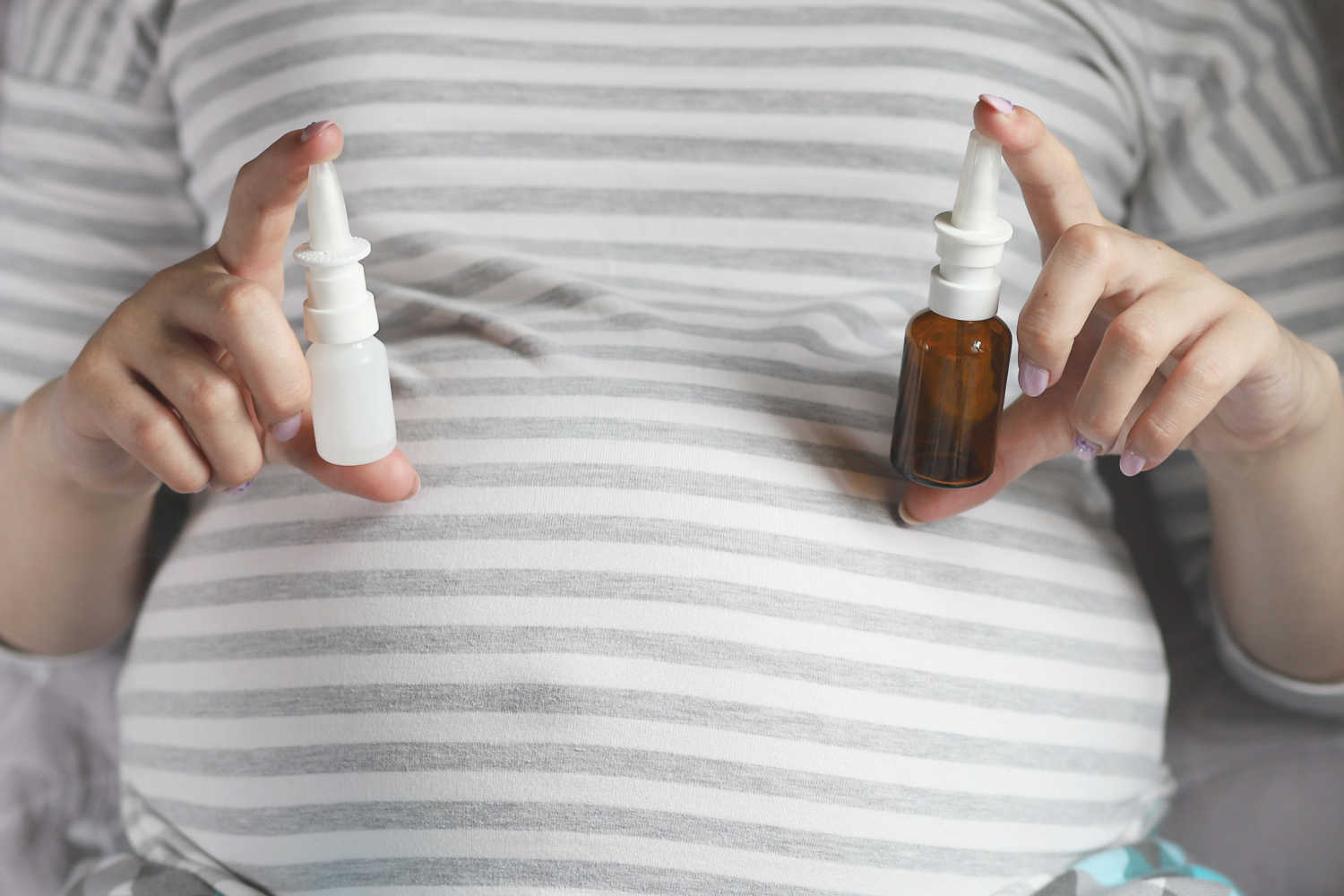 pregnant woman holding nasal drops