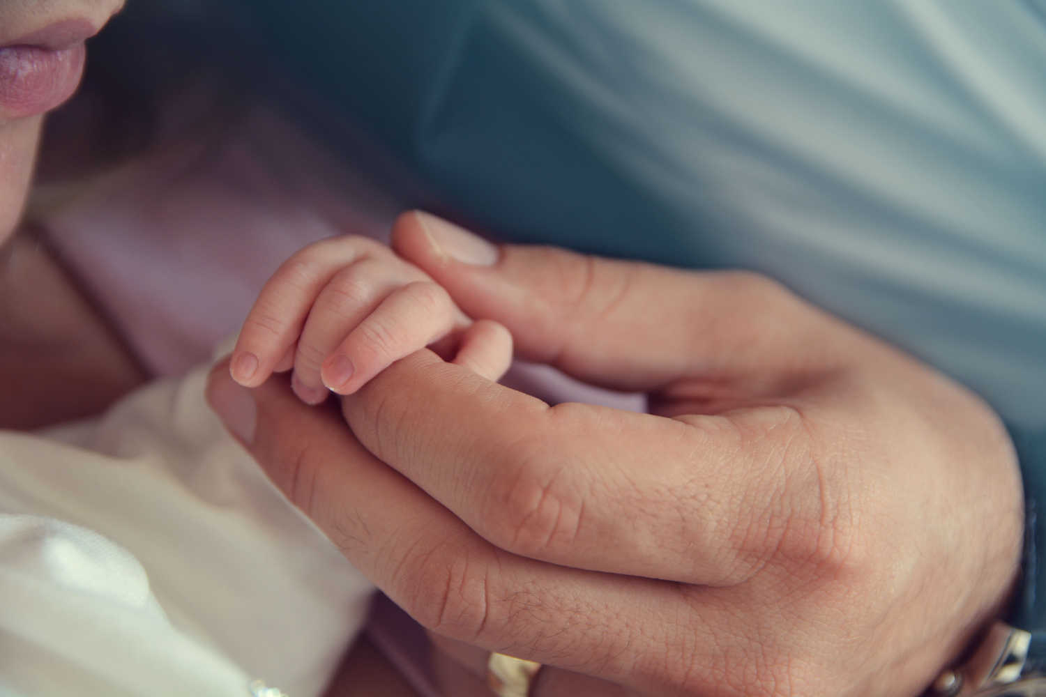 mother holding newborn's hand