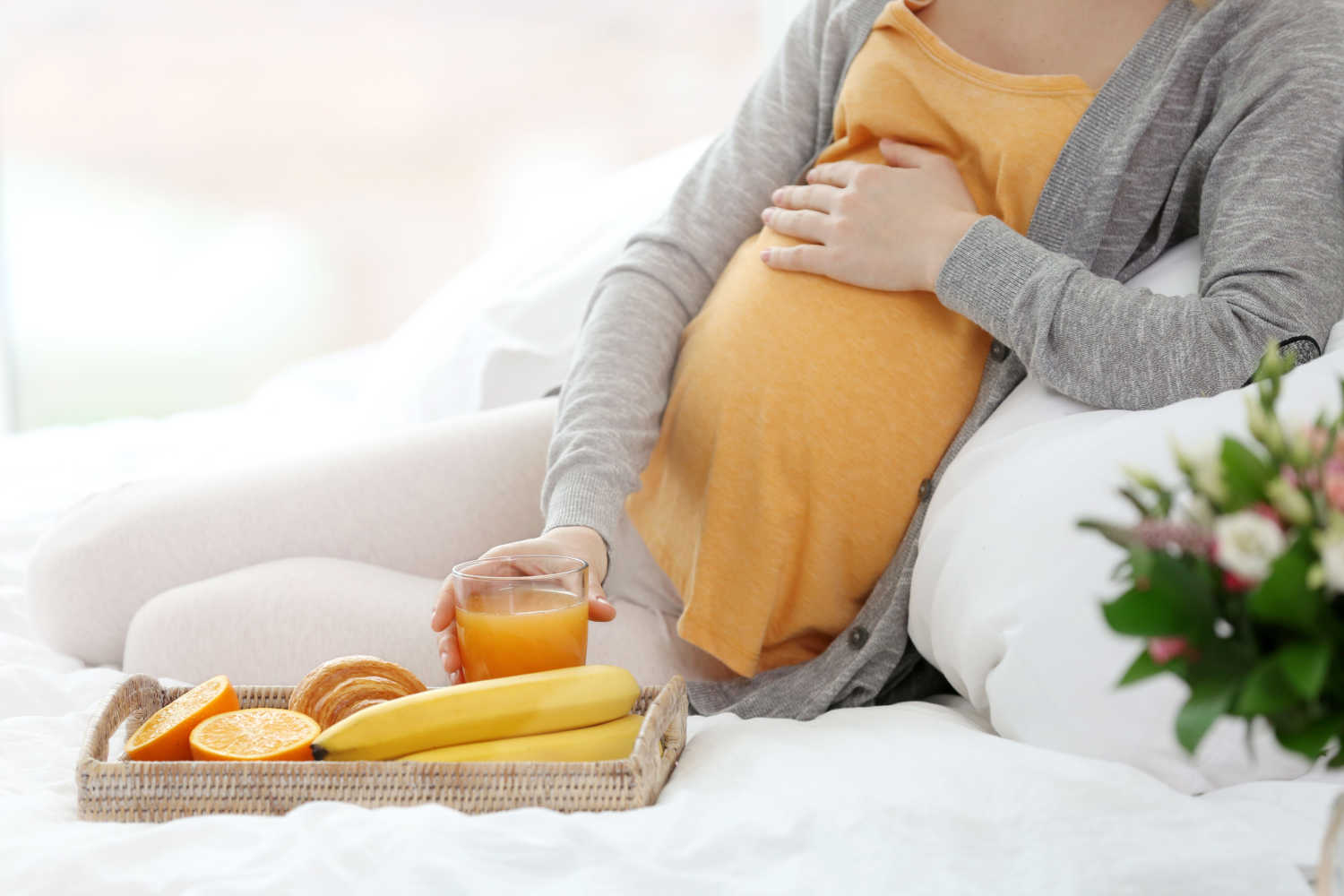 pregnant woman with a  plate of fiber rich foods