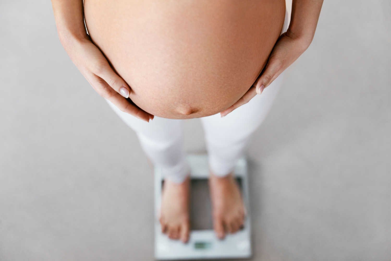 pregnant woman checking weight