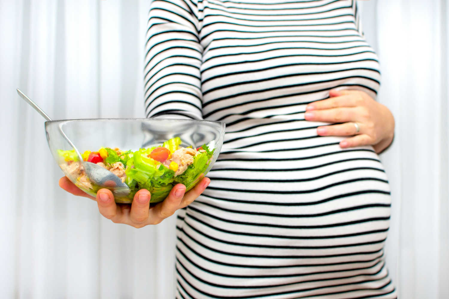 pregnant woman holding food bowl