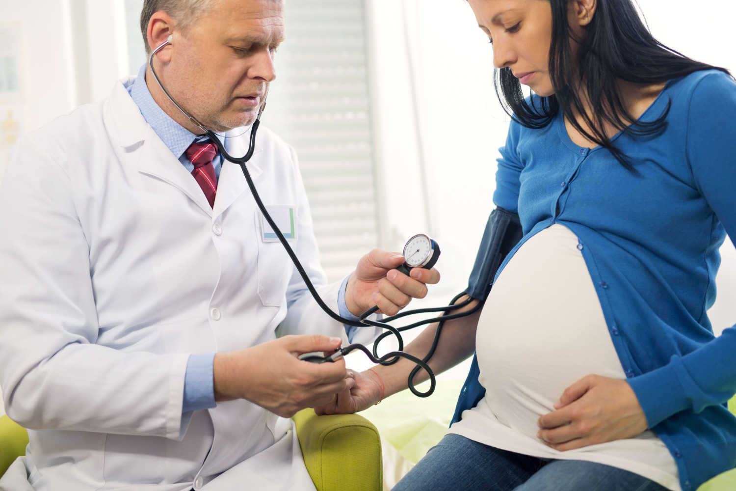 pregnant woman doctor checking bp