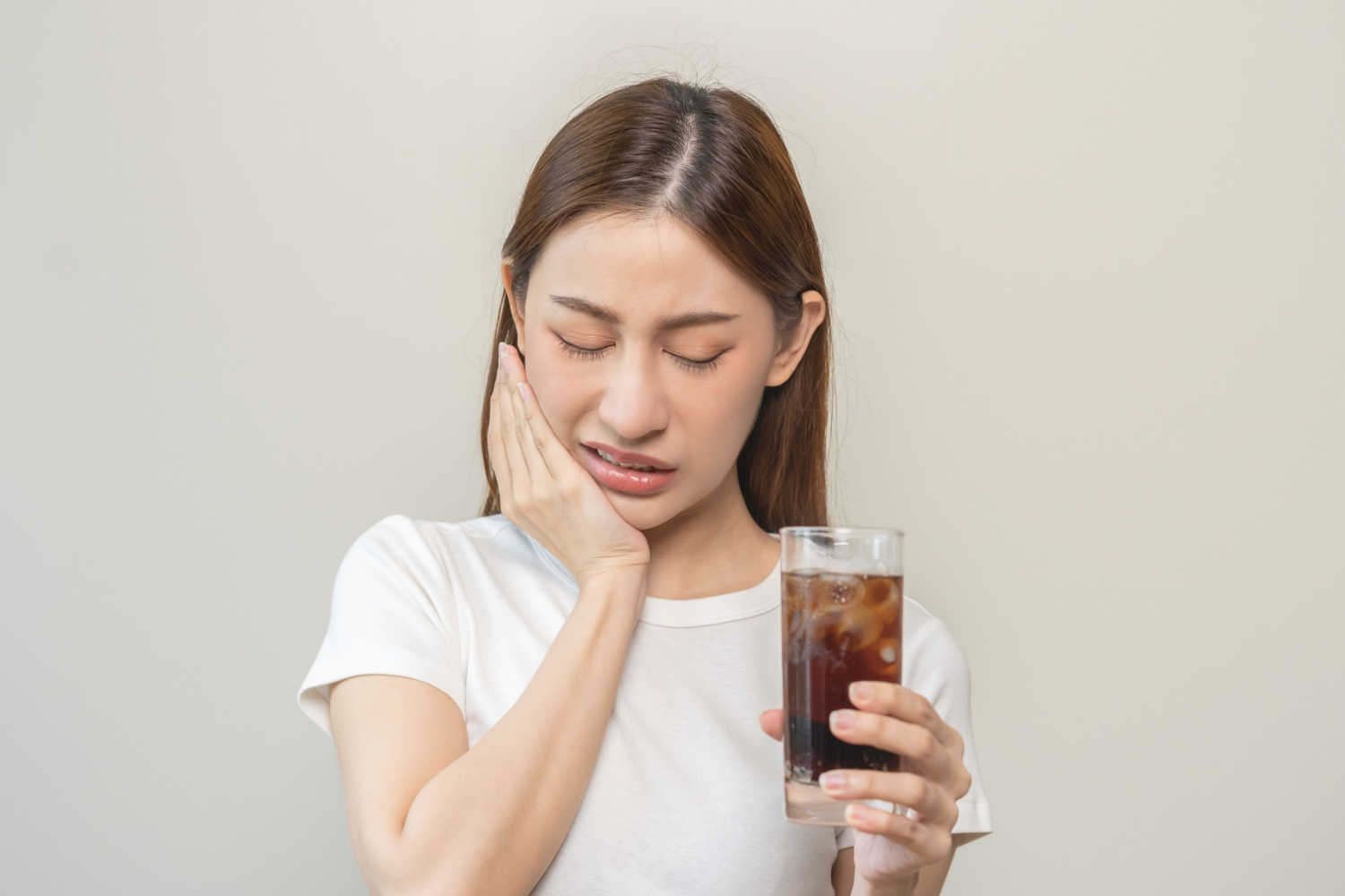 woman having toothache and holding flavored carbonated water
