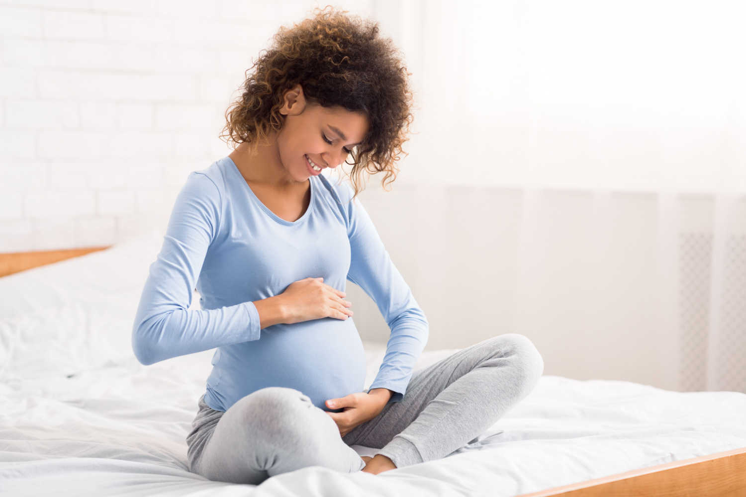 happy pregnant woman embracing her bump