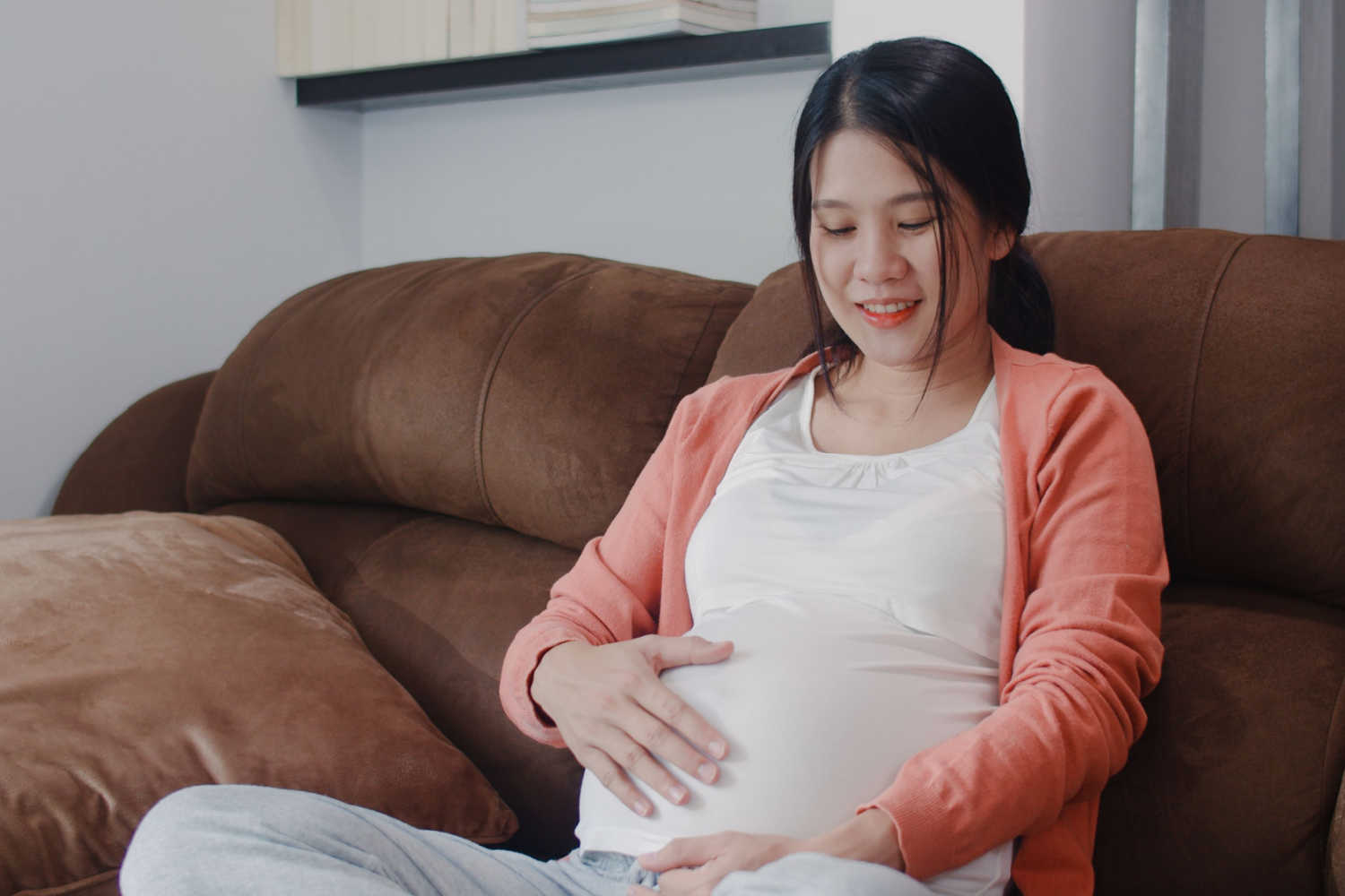 pregnant woman looking at her belly