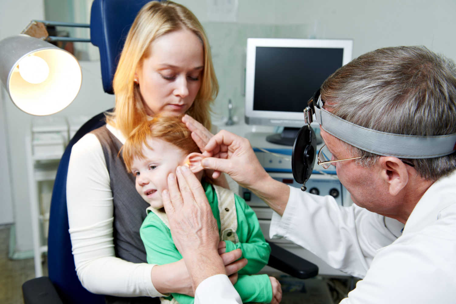 Doctor examining toddler's ear