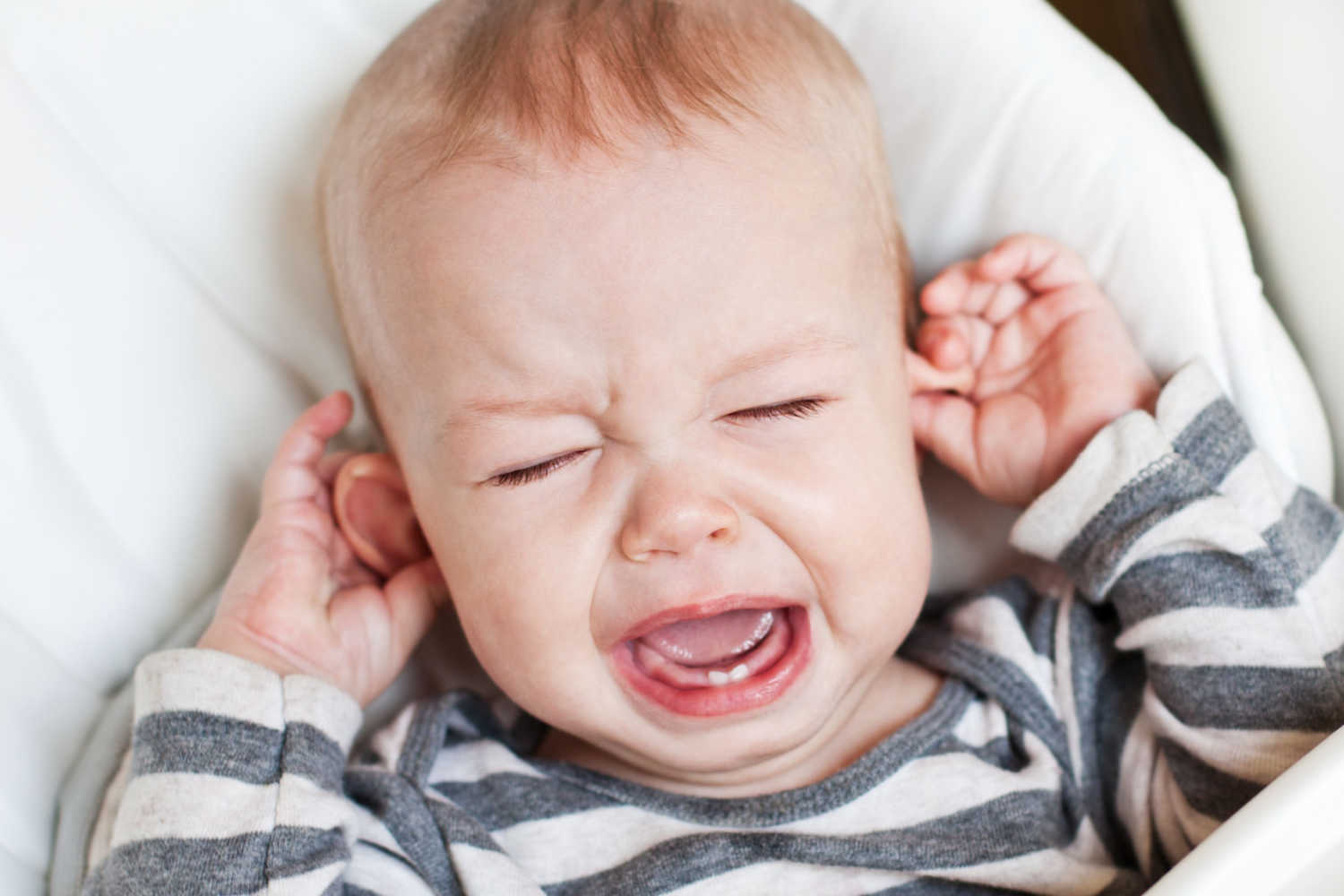 Toddler pulling ears and crying
