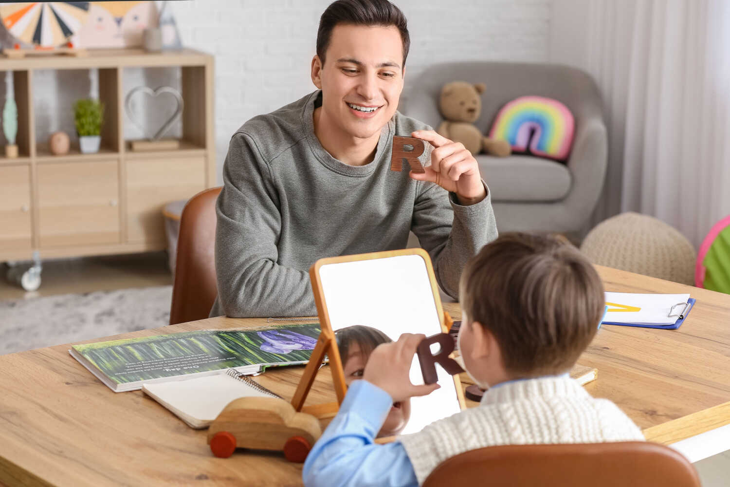 A child doing speech therapy exercise using mirror