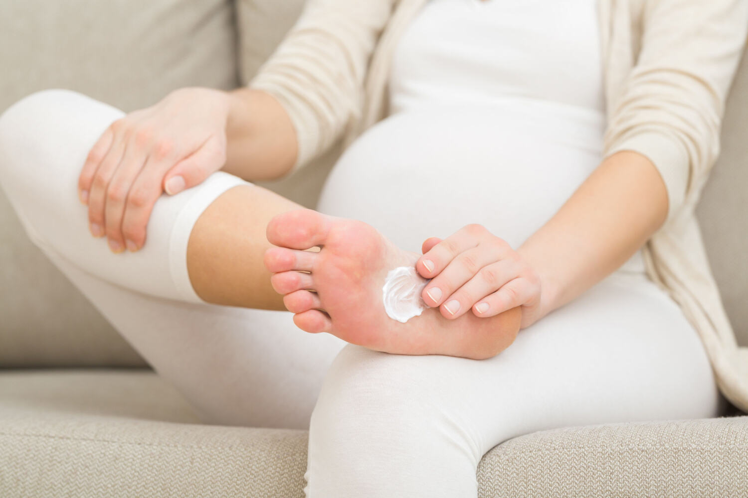 Pregnant women apply cream in legs