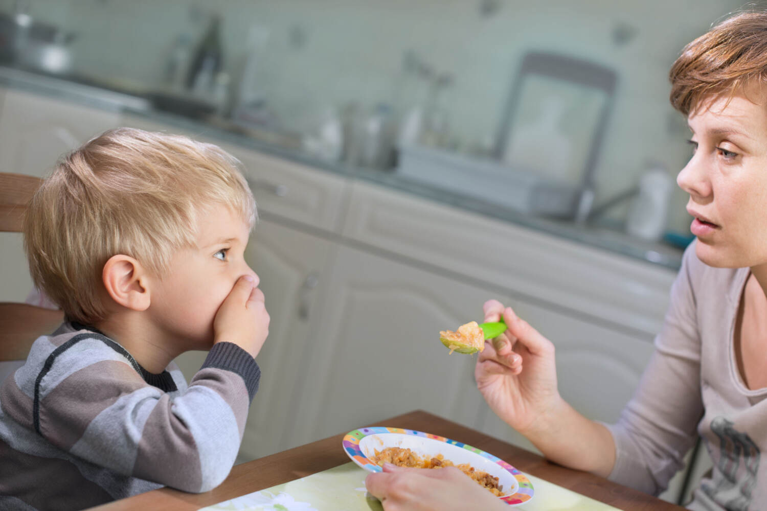 A toddler boy refusing to eat