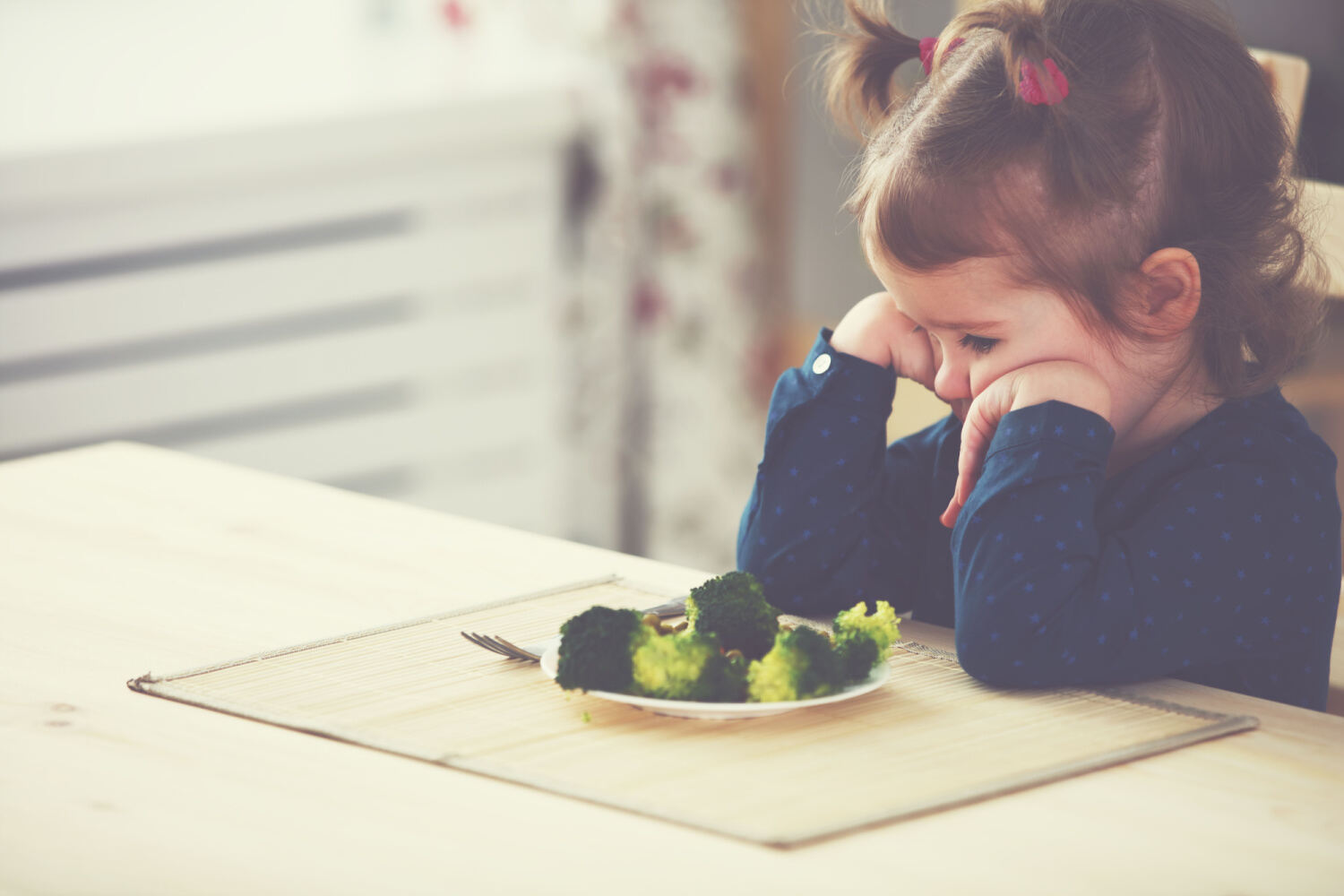 A little girl refusing broccoli