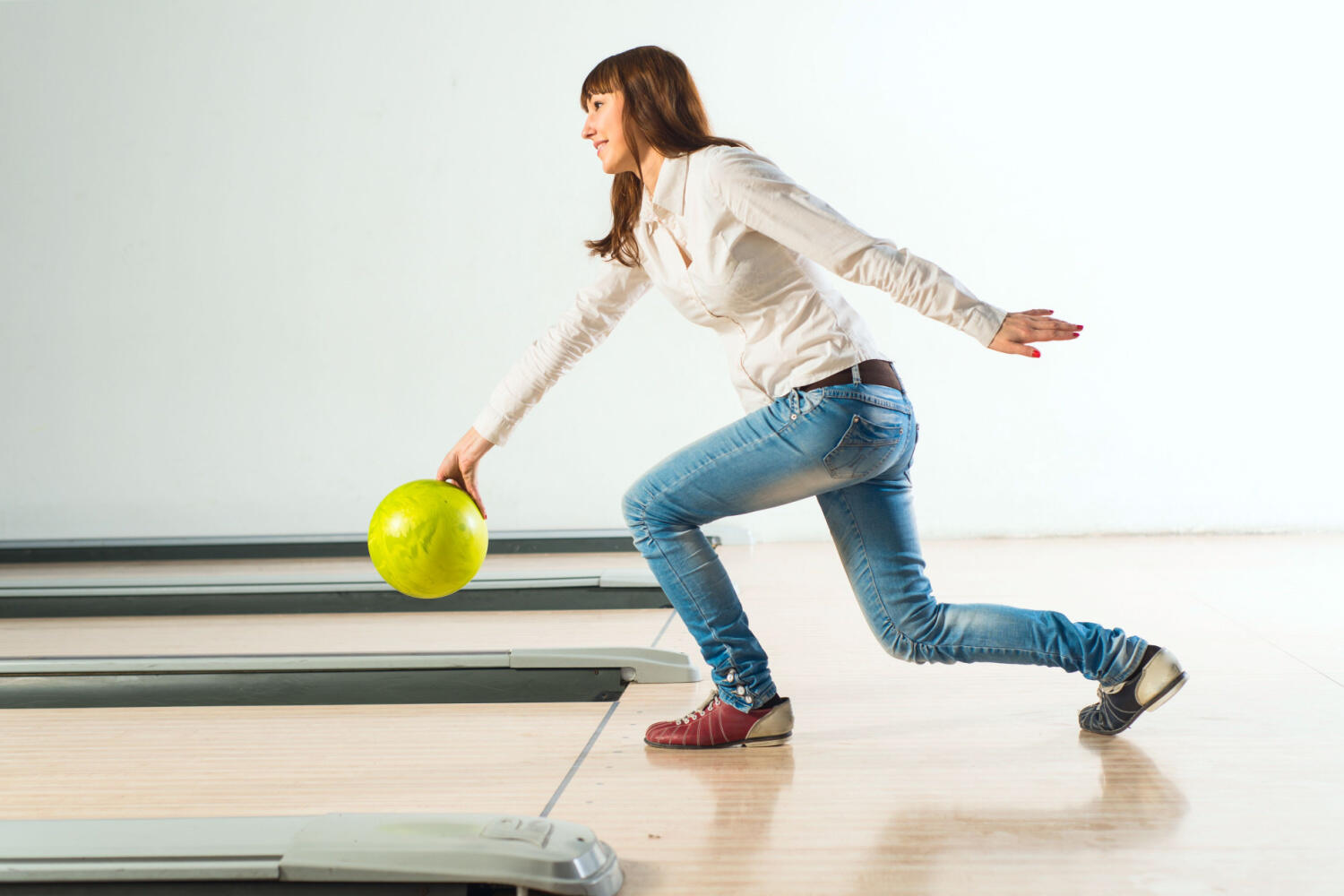 women bent down while bowling