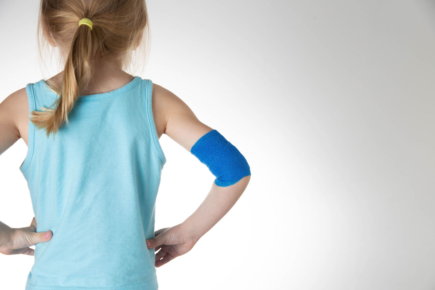 A kid with elastic bandage over elbow
