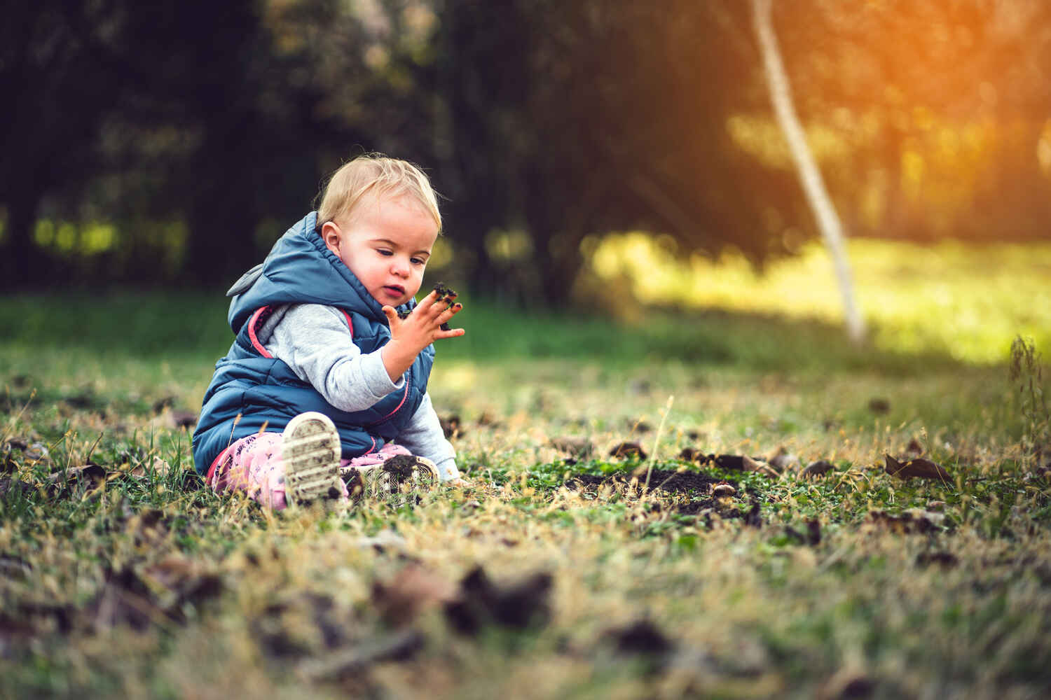 A toddler playing in mud