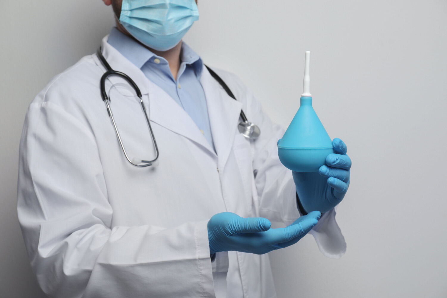 A doctor holding enema apparatus