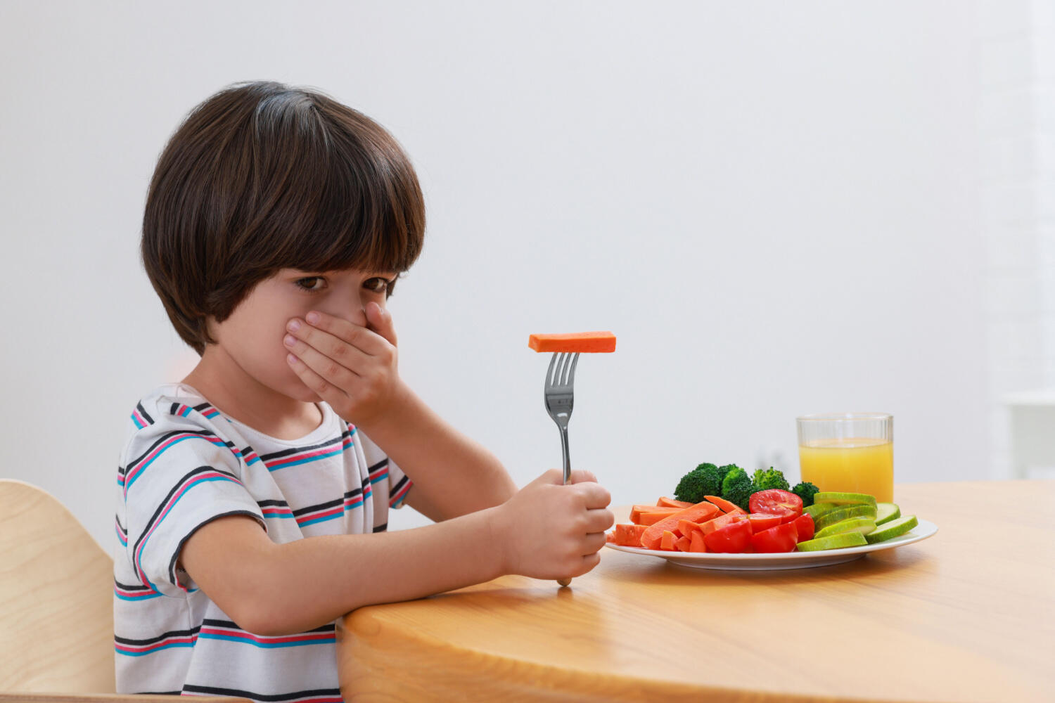 A kid refusing to eat vegetables
