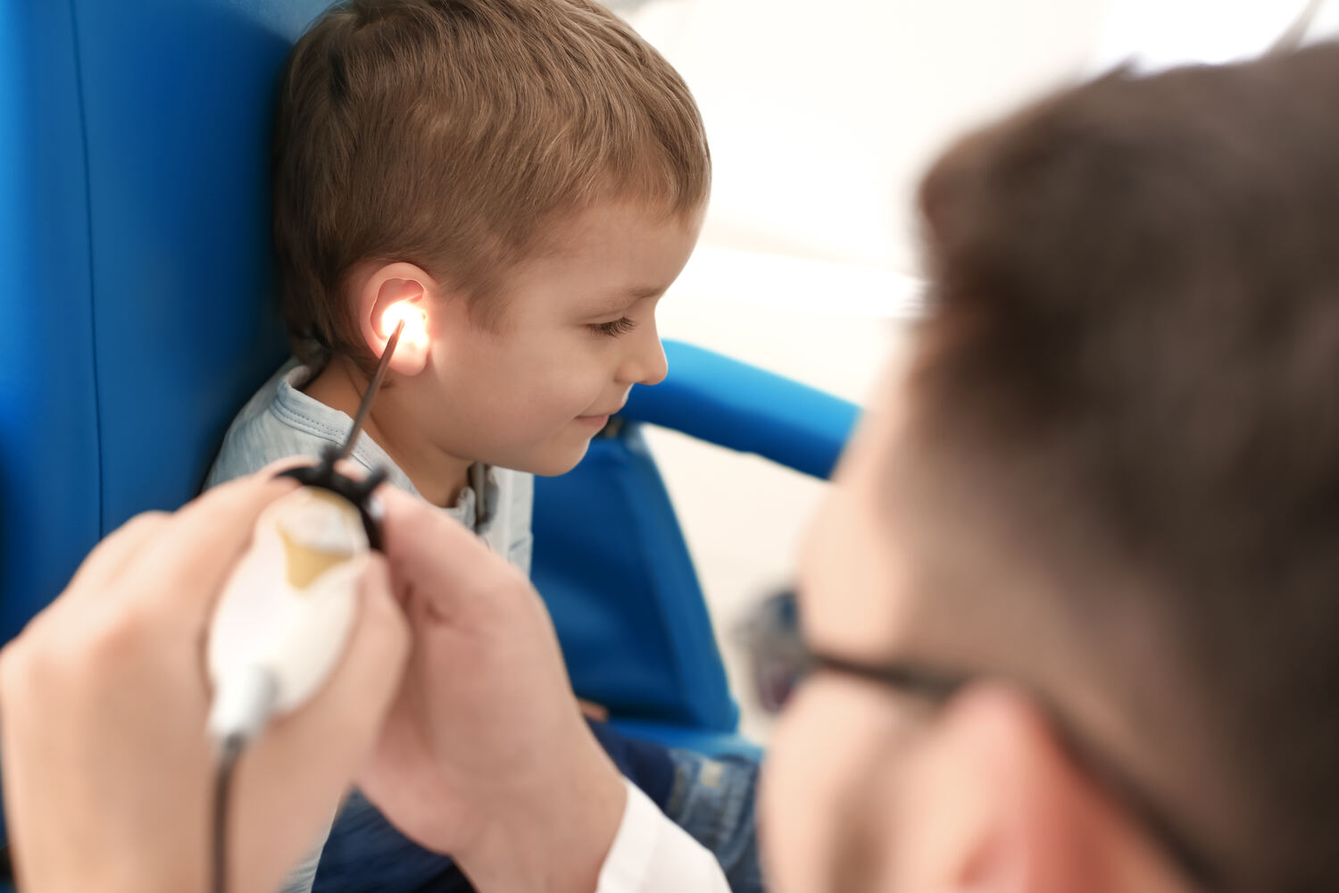 A doctor examining a kid's ear