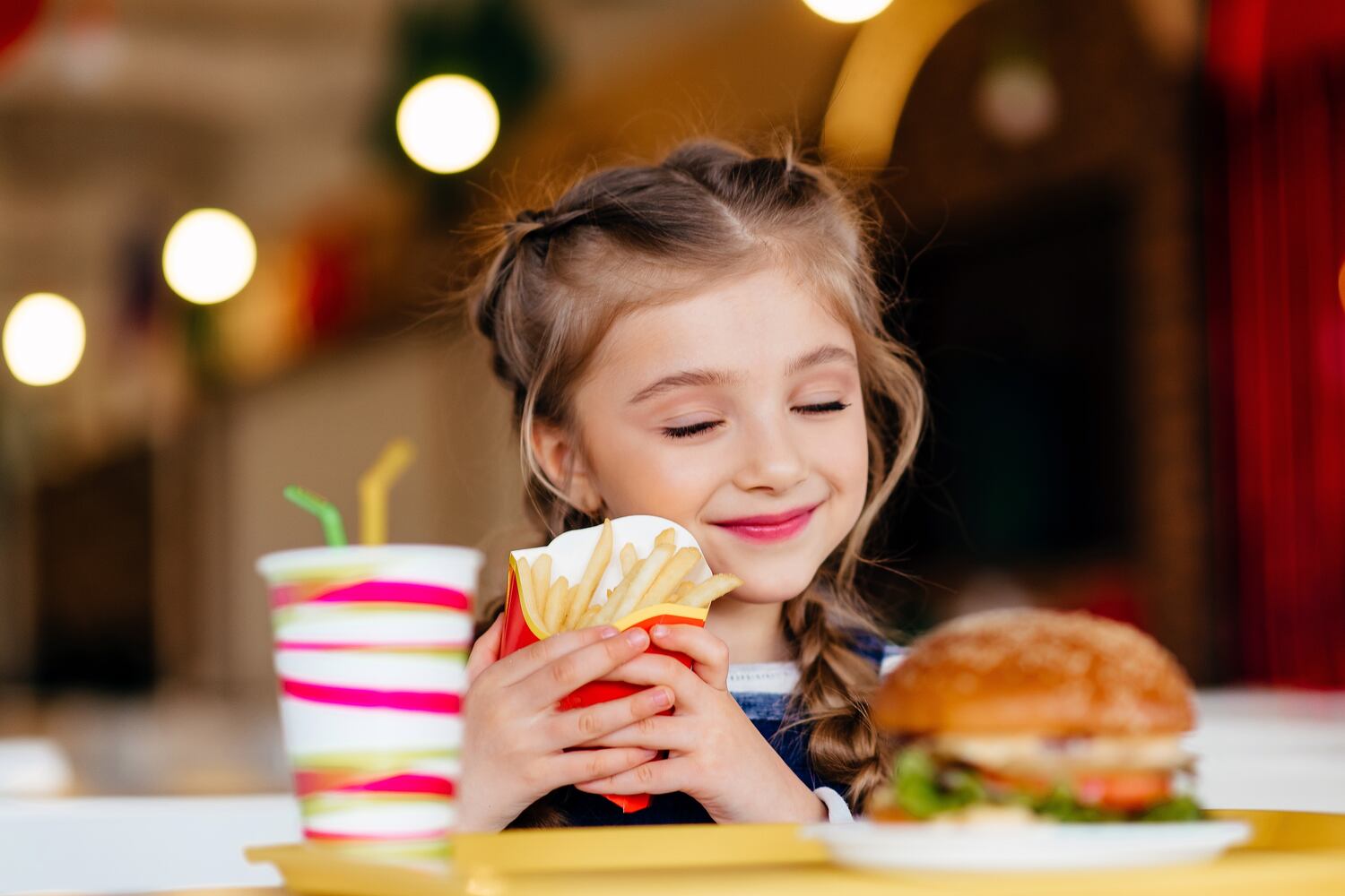 A girl eating junk food which has high sodium