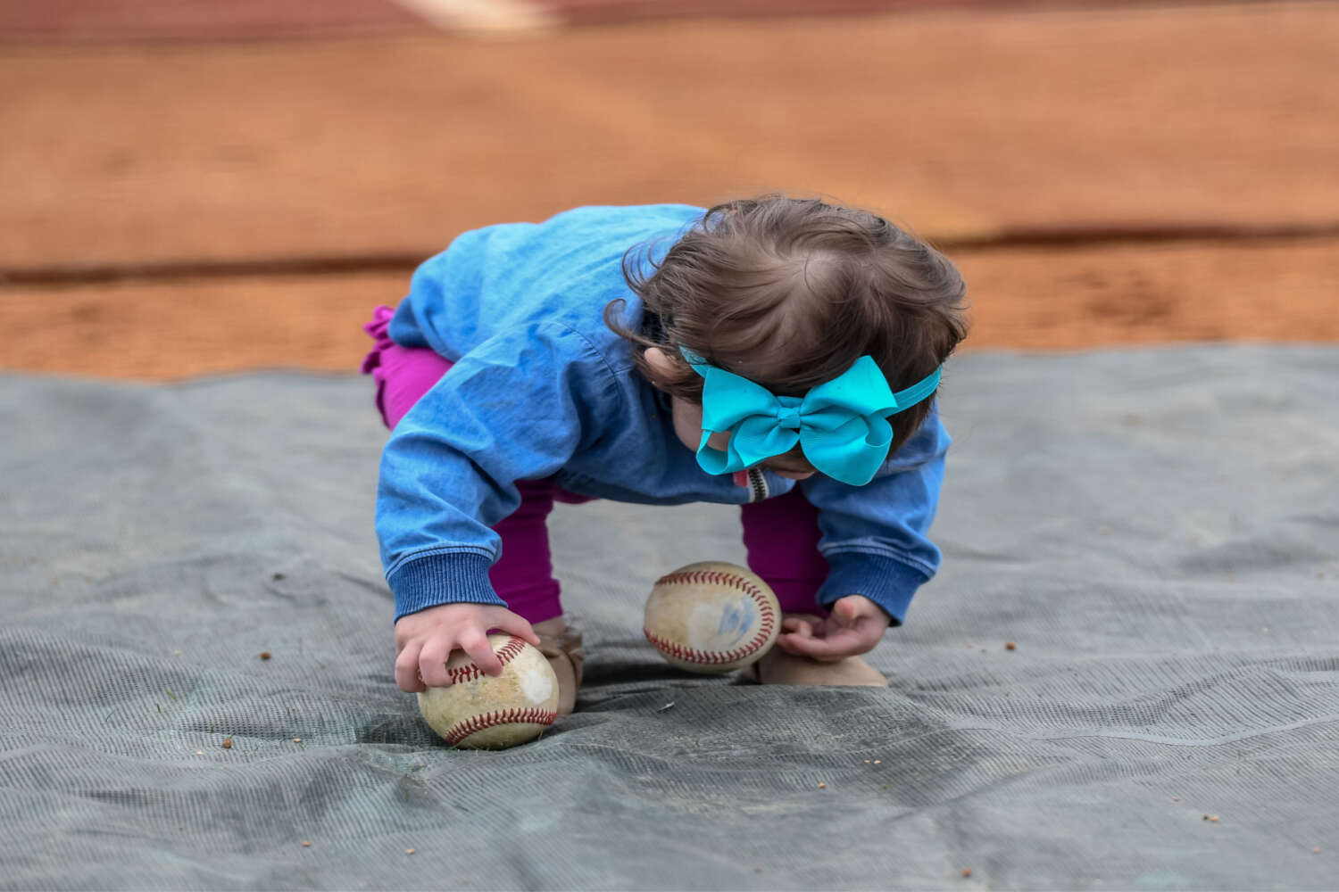 Toddler picking ball from the floor