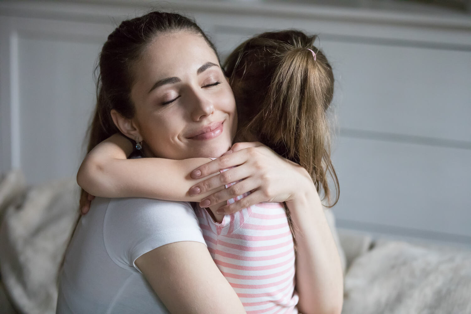 A mother hugging her toddler