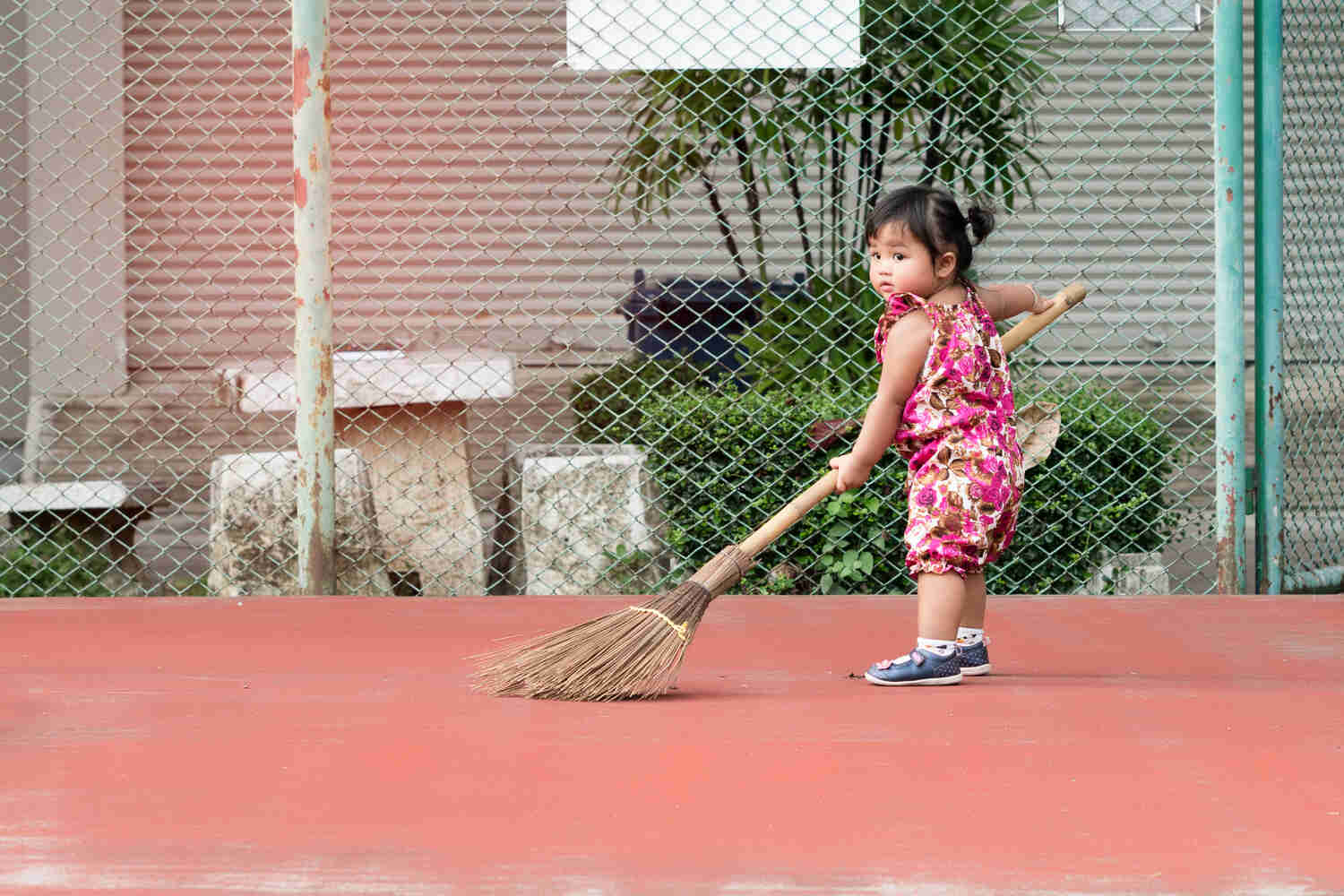A toddler girl sweeping